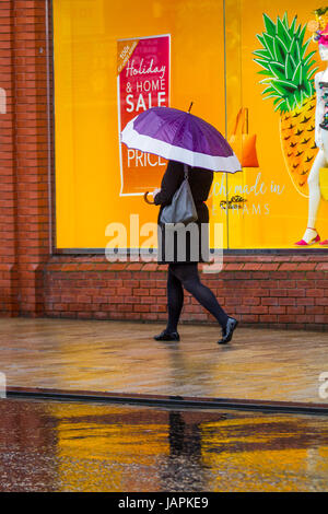 Fishergate, Preston, Lancashire, Regno Unito. 8 Giugno, 2017. Regno Unito Meteo. Gales & Heavy Rain in città. Acquazzoni torrenziali rendono difficile per gli acquirenti che lottano con le forti raffiche di vento, blustery e condizioni ventose. La previsione è per continuare la persistente e spesso heavy rain lentamente evolvendo verso est con forti venti. Credito: MediaWorldImages/Alamy Live News Foto Stock