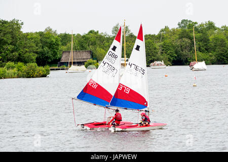 Giovani godendo la loro barca a vela derive a Wroxham ampia in Norfolk. Foto Stock