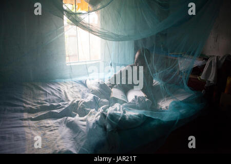 Un bambino che giace sotto una zanzariera, Kenya, Africa Foto Stock