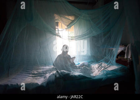 Un bambino che giace sotto una zanzariera, Kenya, Africa Foto Stock