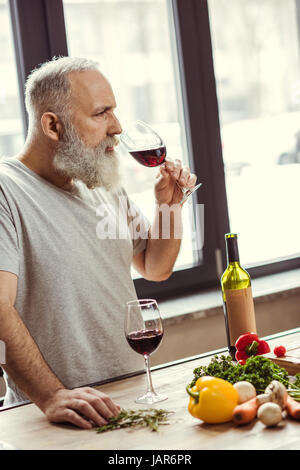 Uomo che cerca di vino rosso Foto Stock