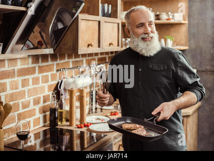 Uomo bistecche di cottura Foto Stock