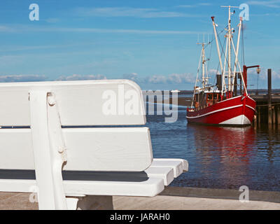 Banca vuota in un porto nel nord della Germania. Foto Stock