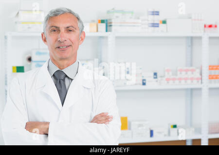Il farmacista in piedi in una farmacia con le braccia incrociate in un ospedale Foto Stock