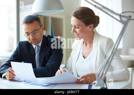 Formalmente vestiti giovani tenendo una discussione in office Foto Stock