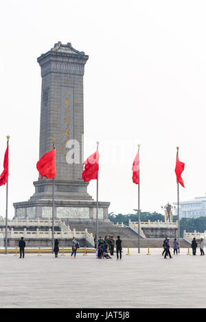 Pechino, Cina - 19 Marzo 2017: turisti e le bandiere rosse vicino al monumento alla popolare di Heroes su Piazza Tiananmen in primavera. Piazza Tiananmen è centra Foto Stock