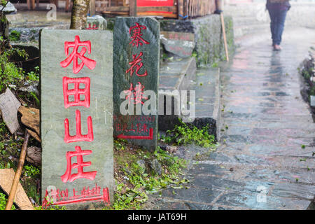 TIANTOUZHAI, Cina - 23 Marzo 2017: cartelli pubblicitari su strada nel villaggio Tiantouzhai di Longsheng Dazhai paese in caso di pioggia. Questo villaggio è nel famoso Foto Stock