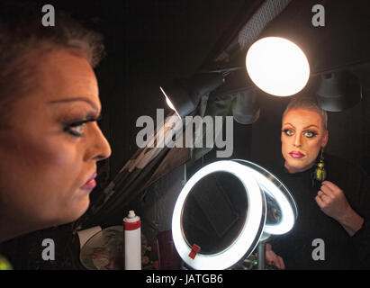Gravi drag queen nella parte anteriore dello specchio con lampada Foto Stock