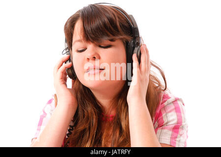 Junges mMädchen mit langen Haaren dunklen hört mit Begeisterung Musik Mit einem vor Kopfhörer weißem Hintergrund. Foto Stock