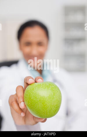 Grande mela verde essendo tenuto da un medico Foto Stock