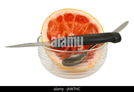 Reste einer roten pompelmo mit Schale, Messer und Löffel; resti di un pompelmo rosso con coppa, un cucchiaio e un coltello Foto Stock