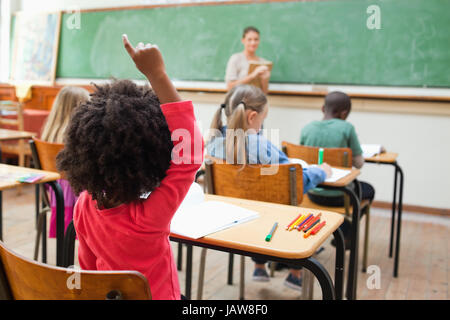 Vista posteriore di una ragazza alzando la mano durante la lezione Foto Stock