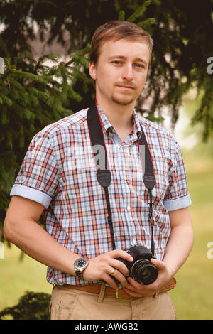 Felice giovane uomo tenere la fotocamera per scattare delle foto fotografo Foto Stock