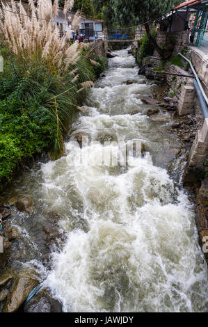 Run-off dalle montagne crea le rapide del fiume in un canale di un villaggio delle Ande. Foto Stock