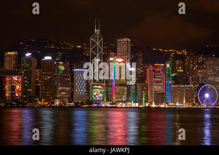 Luce che mostra sui grattacieli e Hong Kong ruota di osservazione, che si riflette nel Porto Victoria, centrale, Isola di Hong Kong, Hong Kong, Cina Foto Stock