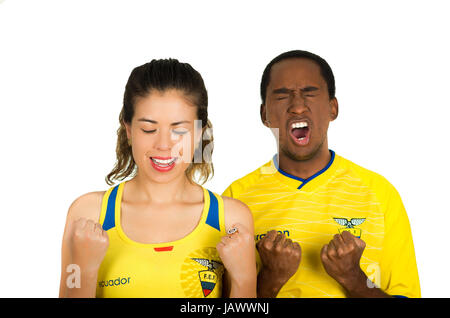 QUITO, ECUADOR - 06 Maggio 2017: giovane coppia ecuadoriana indossando maratona ufficiale Football Shirt in piedi di fronte alla fotocamera, chiudendo gli occhi e che desiderano un miracolo, sfondo bianco Foto Stock