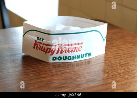 Krispy Kreme cappello di carta sul tavolo in legno Foto Stock