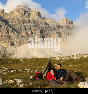 Junge Leute machen Camping in den Bergen vor einer grandiosen Landschaft Foto Stock