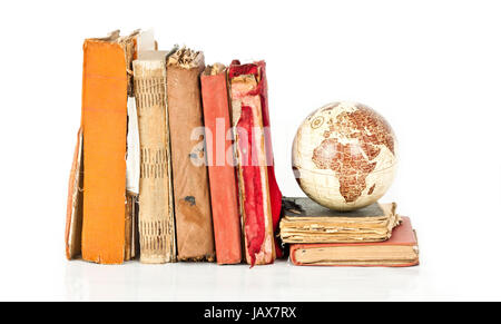 Libri antichi e il pianeta terra isolato su bianco Foto Stock