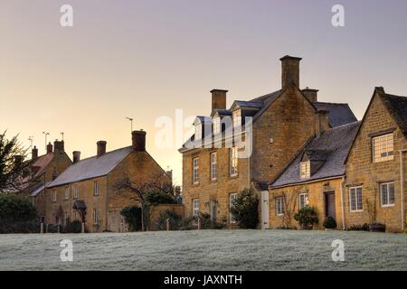 Fila di Cotswold case al tramonto, Willersey near Broadway, Gloucestershire, Inghilterra. Foto Stock