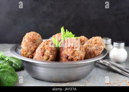 Polpette con grano saraceno in una ciotola di metallo su un grigio Sfondo astratto.il cibo sano.mangiare sano concetto. Foto Stock