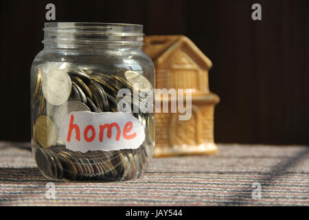 Monete in denaro jar con home etichetta, concetto di finanza Foto Stock