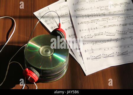 Pila di cd con le cuffie e le note musicali Foto Stock