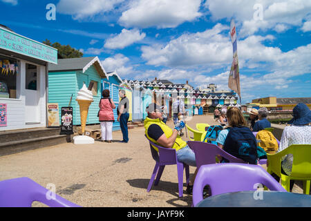 Famiglia godendo di gelato sul lungomare e la spiaggia di capanne, Walton sul Naze, England, Regno Unito Foto Stock