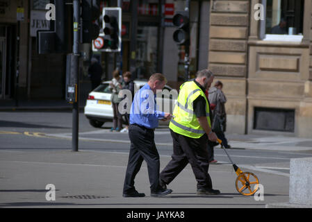 Geometra, ruota con ghiera cliccabile, hodometer, waywiser, trundle ruota, ruota di misurazione o carrozzina essendo utilizzato per misurare la strada di George Square Foto Stock