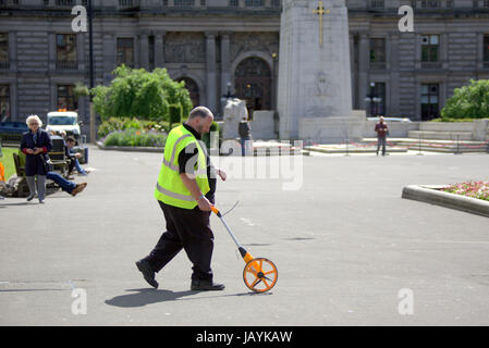 Geometra, ruota con ghiera cliccabile, hodometer, waywiser, trundle ruota, ruota di misurazione o carrozzina essendo utilizzato per misurare la strada di George Square Foto Stock