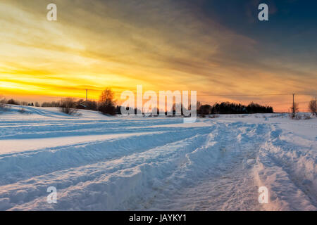 Tracce di motoslitte sul ghiaccio del fiume Pyhajoki nel nord della Finlandia. L'impostazione sole invernale getta luce splendida sulla neve e crea il dramma Foto Stock