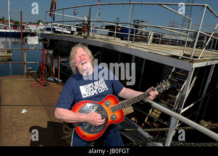 Amburgo, Germania. 26 Maggio, 2017. Musicista Gunter Gabriel a suonare la chitarra al di fuori di casa sua barca presso il porto di Amburgo, Germania, 26 maggio 2017. Gabriel celebra il suo settantacinquesimo compleanno il 11 giugno 2017. Foto: Axel Heimken/dpa/Alamy Live News Foto Stock