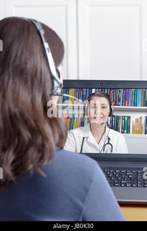 Donna con cuffie e il computer portatile effettuando una chiamata video con il suo medico, di copia o lo spazio di testo, e-health, telesanità o concetto di telemedicina Foto Stock