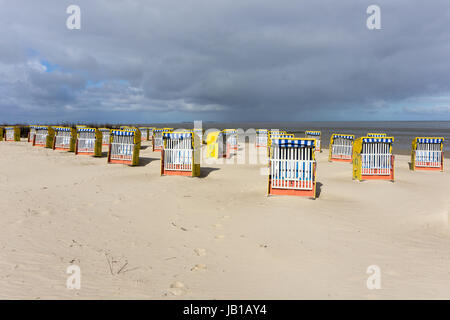 Nuvole scure sul mare del Nord, sedie a sdraio sulla spiaggia sabbiosa, Cuxhaven, Bassa Sassonia, Germania Foto Stock