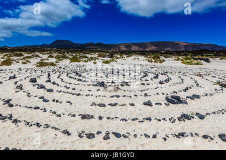 Una pietra rotonda pattern nella sabbia di una spiaggia a Lanzarote. Foto Stock