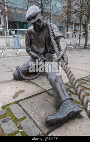 La statua in bronzo di nome 'l' per guardafili da Dony Mac Manus situato sul molo della città sulle rive del fiume Liffey, Dublino, Irlanda. Foto Stock