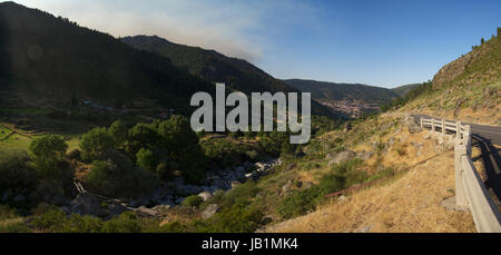 Tipico a forma di U valle glaciale Manteigas vicino a Estrela mountain range (Serra da Estrela). Panoramica strada asfaltata si percorre la valle e alcuni clou Foto Stock