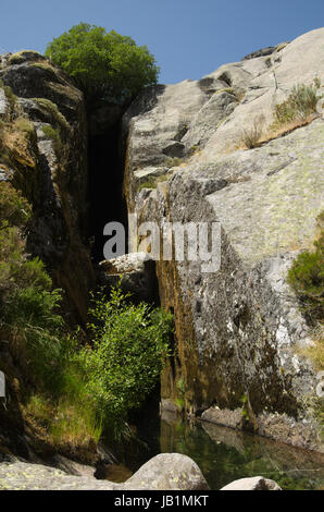 Prospettica di una fessura nella roccia e un piccolo stagno: il luogo di nascita del Fiume Zezere a Covao d'Ametade. Estrela mountain range (Serra da Estrela), Po Foto Stock