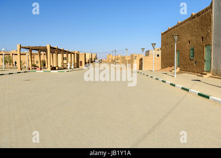 Merzouga, Marocco - Jan 6, 2017: Sulla strada nel villaggio di Merzouga. Due uomini marocchini in bianco djellaba talk su strada Foto Stock