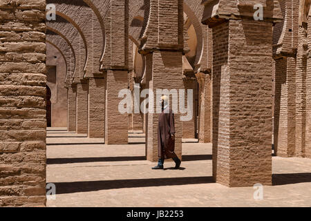 Vestito tradizionale uomo cammina all'interno della moschea Tinmal, Marocco. Foto Stock