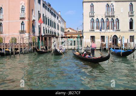 Con le gondole e gondolieri passeggeri sul Canal Grande e splendidi palazzi. Venezia, Italia, Europa. Foto Stock