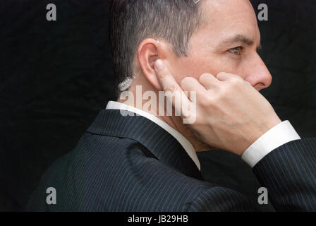 Close-up di un agente dei servizi segreti ascoltando il suo auricolare, lato. Foto Stock