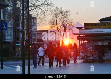 La strada principale dello shopping di l'isola del Lido, il Gran Viale Santa Maria Elisabetta, illuminata da una fiamma rosso tramonto. L'Italia, l'Europa. Foto Stock