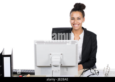 Junge hübsche, Büroangestellte sitzt am Schreibtisch im Büro vor dem PC Foto Stock