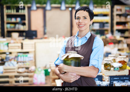 Gentile proprietario del negozio al lavoro Foto Stock