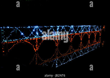 Modifica stilizzata del piede illuminato ponte tra la parte del lago e la sua riflessione a Blenheim Palace di luci di Natale. Dicembre 2016 Foto Stock