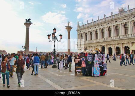Scenario di Piazza San Marco con le doppie colonne di San Marco e di San Teodoro. Turisti e un souvenir in stallo. Venezia, Italia, Europa. Foto Stock