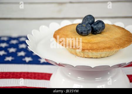 Mirtilli maturi su mini torta con bandiera americana Foto Stock