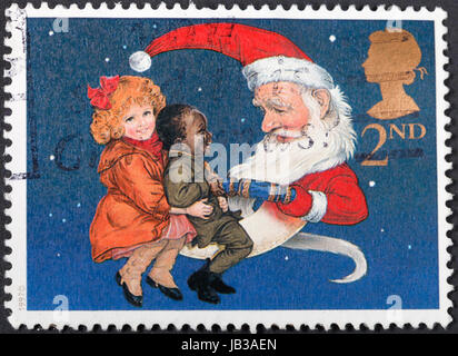 Regno Unito - circa 1997: un francobollo stampato nel Regno Unito mostra i bambini e Babbo Natale tirando un cracker di Natale , circa 1997 Foto Stock