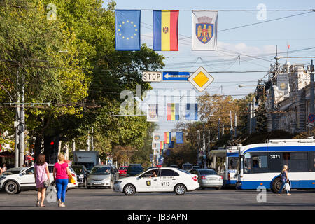 27.08.2016, Moldavia, Chisinau, Chisinau - la bandiera della Repubblica di Moldavia, la bandiera dell'UE come pure una bandiera con lo stemma di Chisinau accanto a ogni altro sopra la Bulevardul Stefan cel Mare si Sfint sul giorno di indipendenza della Repubblica. Un segnale di stop, una strada a senso unico e un diritto di modo. Questi segnali contraddittori tristemente simboleggiano le incerte prospettive della repubblica, anche con riguardo ad un aspirava l adesione all UE. Nella foto anche una pattuglia di polizia stradale (politia patrulare). 00A160827D301CAROEX.JPG - non per la vendita in G E R M A N Y, A U S T R I A, S W I T Z e R L A N D [modello di rilascio: Foto Stock